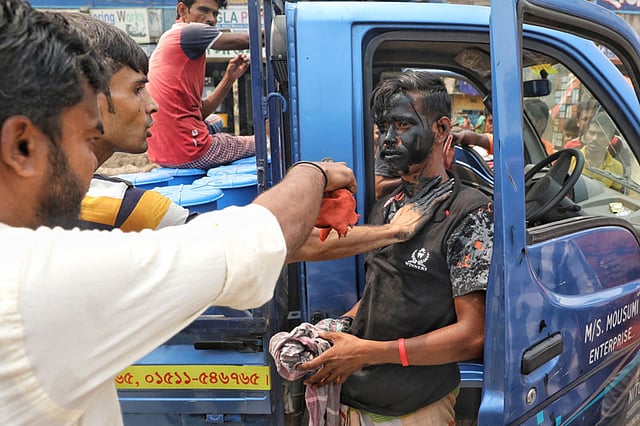 লাইসেন্স না থাকায় চালকের মুখে পোড়া ইঞ্জিন ওয়েল মাখানো হচ্ছে। ছবি: দীপু মালাকার