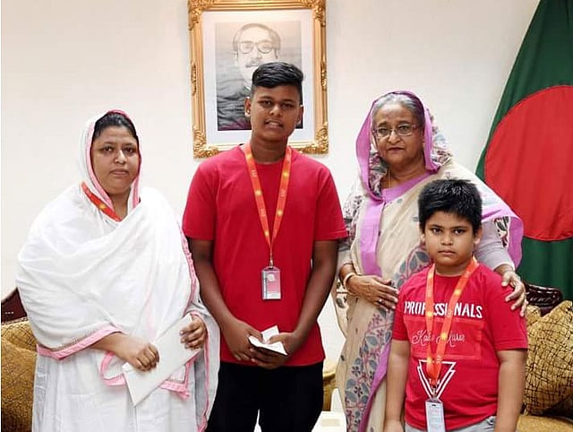 প্রধানমন্ত্রীর কাছ থেকে অনুদানের চেক নিচ্ছে একটি পরিবার। ছবি: প্রধানমন্ত্রীর কার্যালয়