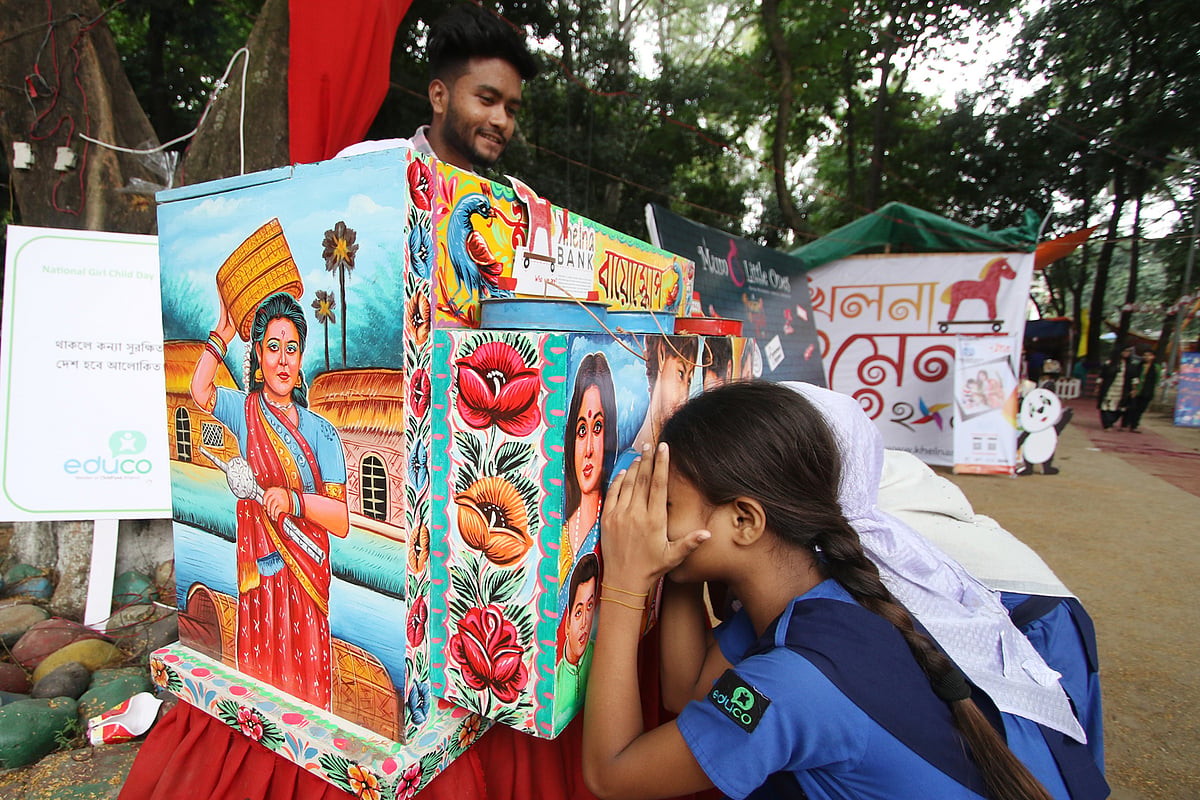 মেলায় এসে বায়োস্কোপ দেখছে শিশুরা।