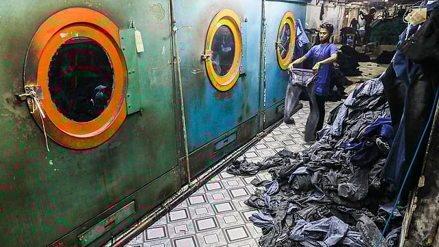 কেরানীগঞ্জের জিনস প্যান্টের ফ্যাক্টরিতে কাজ করছেন এক কর্মী। বিভিন্ন ধরনের জিনস প্যান্ট সেলাইয়ের পর রং দেওয়া হলে তা স্থায়ী করার জন্য ওয়াশ করতে আনা হয় এখানে। গুদারাঘাট, ১২ অক্টোবর। ছবি: দীপু মালাকার