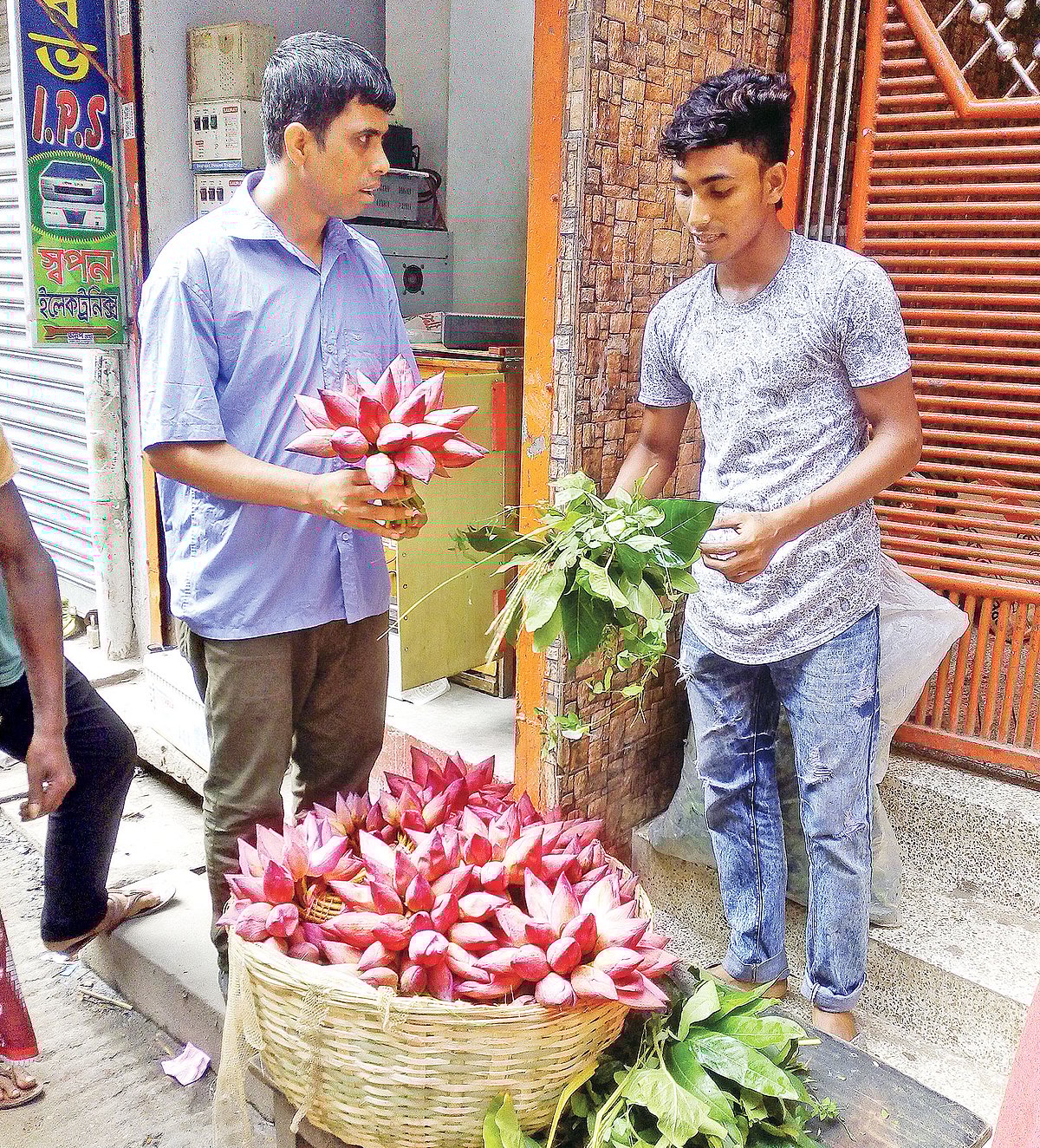 পূজার জন্য পদ্ম ফুল কিনছেন এক ভক্ত। গতকাল শাঁখারীবাজারে।  ছবি: জয়দেব সরকার