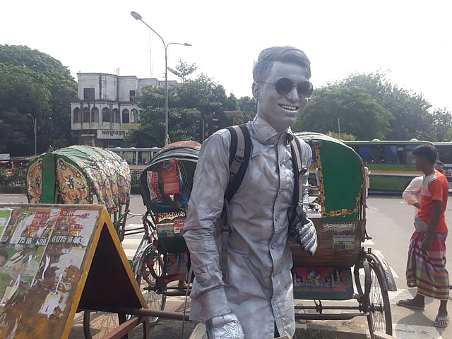 শাহবাগ মোড়ে ‘সিলভার ম্যান’ সেজে দাঁড়িয়ে আছেন সিদ্দিকুর।ছবি : আসাদুজ্জামান