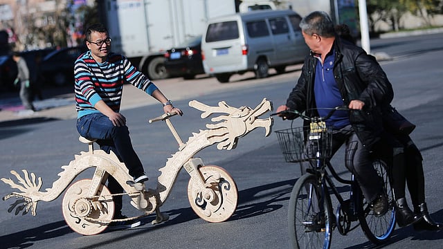 সড়কে চলছে ড্রাগন আকৃতির সাইকেল। সাইকেলটি বানানো হয়েছে আইসক্রিমের কাঠি দিয়ে। তিয়েলিং, লায়োনিং প্রদেশ, চীন, ১৫ অক্টোবর। ছবি: রয়টার্স
