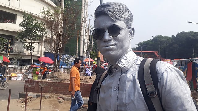 শাহবাগ মোড়ে ‘সিলভার ম্যান’ সেজে দাঁড়িয়ে আছেন সিদ্দিকুর।ছবি : আসাদুজ্জামান