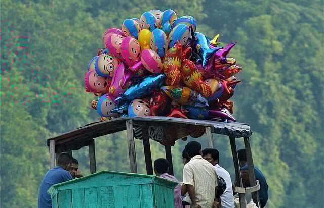 মানুষ, পাখি, মাছসহ বিভিন্ন প্রাণীর আদলে তৈরি খেলনা বেলুন বিক্রির জন্য সাপ্তাহিক হাটে নিয়ে যাচ্ছেন এক ব্যক্তি। সুবলং ঝরনা এলাকা, বরকল উপজেলা, রাঙামাটি, ১৯ অক্টোবর। ছবি: সুপ্রিয় চাকমা