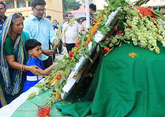 ফাদার রিগনকে শ্রদ্ধা জানাতে এসেছে এই শিশুও। উপজেলা পরিষদ মাঠ, মোংলা, বাগেরহাট, ২১ অক্টোবর। ছবি: প্রথম আলো