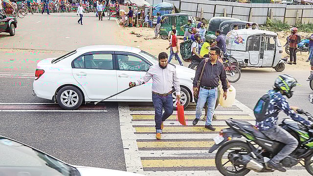 নানা কর্মসূচির পরও রাস্তায় ফেরেনি শৃঙ্খলা। জেব্রা ক্রসিং পেরিয়ে গাড়ি। এর মধ্য দিয়েই চলতে হচ্ছে পথচারীদের। গতকাল বেলা দুইটায় বিমানবন্দর সড়কের শেওড়া এলাকায়।  প্রথম আলো