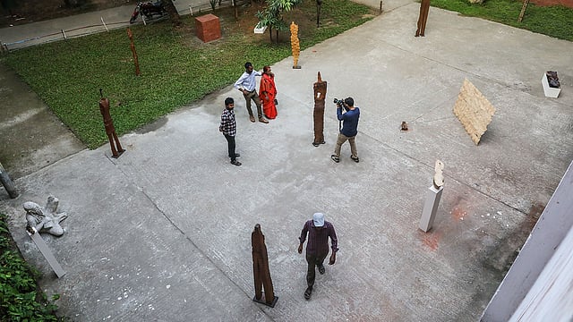 ঢাবির চারুকলা অনুষদের ভাস্কর্য বিভাগ প্রাঙ্গণে সুমন বর্মনের ‘জাদুতে জল’ শীর্ষক একক ভাস্কর্য প্রদর্শনী অনুষ্ঠানে দর্শনার্থীরা। ঢাকা বিশ্ববিদ্যালয়, ২৭ অক্টোবর। ছবি: দীপু মালাকার