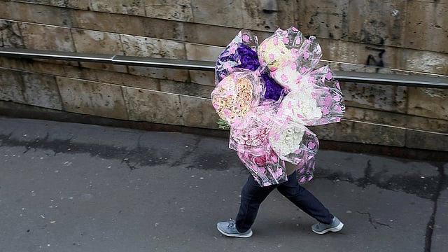 ফুলের পসরা সাজিয়ে যাচ্ছেন এক বিক্রেতা। কিয়েভ, ইউক্রেন, ২৬ অক্টোবর। ছবি: রয়টার্স