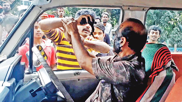 ৪৮ ঘণ্টার পরিবহন ধর্মঘটের মধ্যে গাড়ি চালানোর কারণে এক মাইক্রোবাস চালকের মুখে পোড়া মবিল মেখে দেন আন্দোলনকারী শ্রমিকেরা। ঠাকুরগাঁও শহরের পুরোনো বাসস্ট্যান্ড এলাকায়।  ছবি: মজিবর রহমান