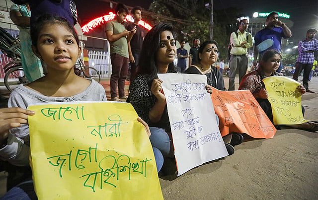 বৃত্তাকার হয়ে বসে বিভিন্ন প্রতিবাদী স্লোগান সংবলিত প্ল্যাকার্ড ধরেন তাঁরা