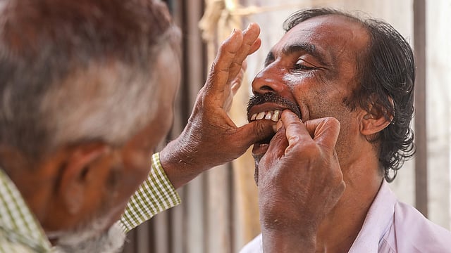 আঙুল দিয়ে টেনে দাঁত তোলা হচ্ছে।