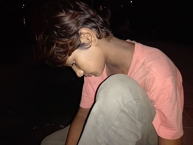 বিষণ্ন মনে বসে আছে মা-বাবাহারা ছেলেটি। তার দিনরাত কাটে হাতিরঝিলে। ঢাকা, ২০ অক্টোবর ২০১৮। ছবি: প্রথম আলো