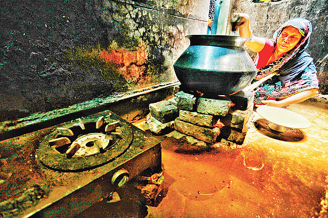 ভোর ৬টা থেকে গ্যাস নেই। বিকল্প ব্যবস্থায় রান্না। গতকাল দুপুর সাড়ে ১২টায় ঢাকার গেন্ডারিয়ার বাজার রোড এলাকায়।  ছবি: প্রথম আলো