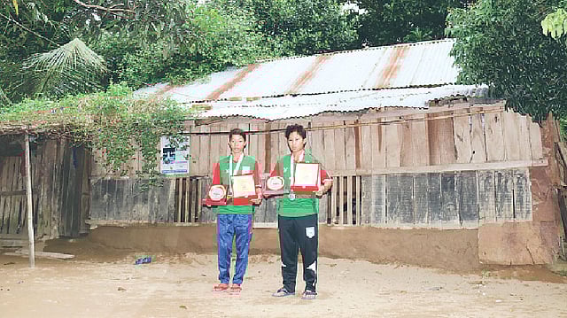 সাফল্যের স্মারক হাতে খাগড়াছড়ির সাত ভাইয়াপাড়ায় বাড়ির সামনে দুই বোন। প্রথম আলো