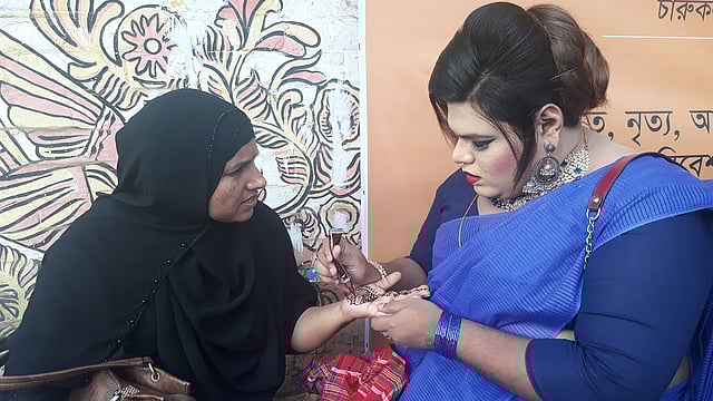 এক নারীর হাতে মেহেদি রাঙিয়ে দিচ্ছেন এক হিজড়া। ঢাকা, ১১ নভেম্বর। ছবি: প্রথম আলো