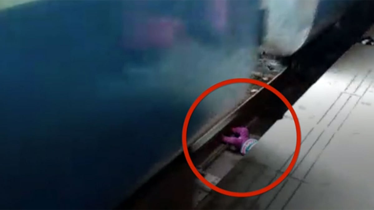 রেললাইনের ফাঁকে পড়ে আছে এক বছরের শিশুটি। ছবিটি বিবিসির ভিডিও থেকে নেওয়া