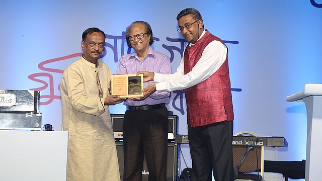 আলাউদ্দীন আলীকে স্মারক তুলে দেন শিল্পী মুস্তাফা মনোয়ার ও এন রাজাশেখর। ছবি: প্রথম আলো