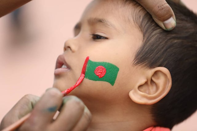 এক শিশুর গালে আঁকা বাংলাদেশের পতাকা। ছবি: দীপু মালাকার