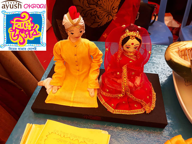 বিদ্যানন্দ ফাউন্ডেশনের স্টলে বর-কনের সাজে পুতুল। ছবি: মানসুরা হোসাইন