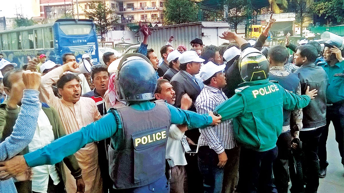 ঢাকা–১৪ আসনে আওয়ামী লীগের প্রার্থী আসলামুল হকের সমর্থকেরা বিএনপির প্রার্থী আবু বকর সিদ্দিকের বাড়ির দিকে যেতে চাইলে বাধা দেয় পুলিশ। গতকালের ছবি।  প্রথম আলো