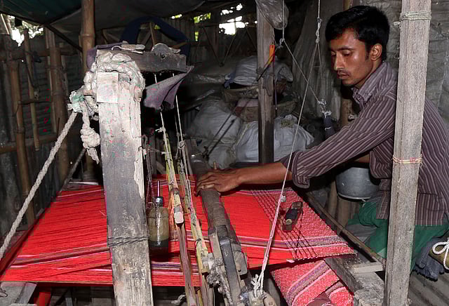 তাঁতে কাজ করছেন এক ব্যক্তি। ছবি: সোয়েল রানা