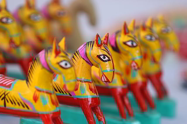 বাহারি রঙের কাঠের ঘোড়া বিক্রি হচ্ছে এক স্টলে।