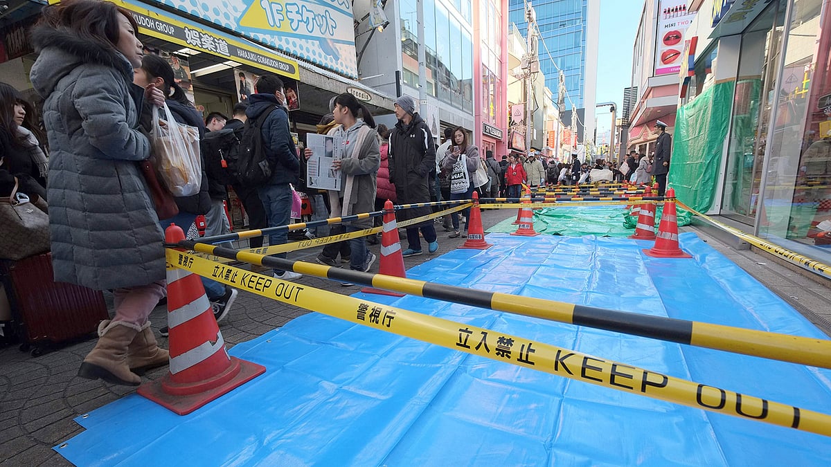 জাপানের টোকিওর একটি সড়কে নতুন বছরকে স্বাগত জানাতে আসা মানুষের ওপর গাড়ি তুলে দেওয়া হয়। এ ঘটনার পর ওই স্থান ঘিরে রাখে পুলিশ। ছবি: এএফপি