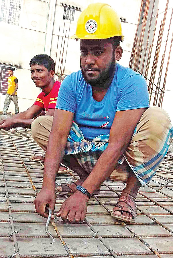 নির্মাণশ্রমিকের কাজে  মাহবুবুর।  প্রথম আলো