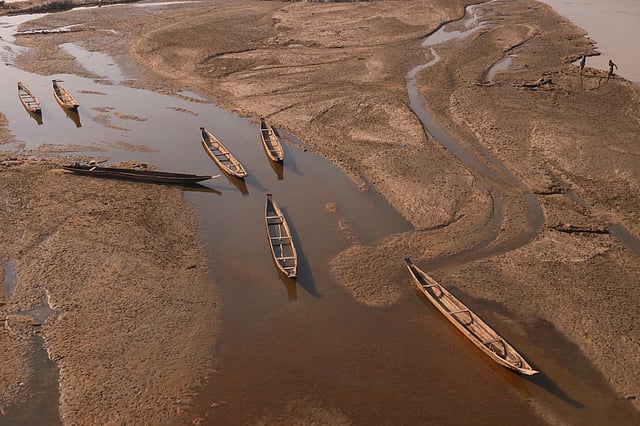 শীতে নদের বুকে জেগে ওঠে চর। চরে পড়ে আছে পাথর শ্রমিকদের বারকি নৌকা। ছবি: আনিস মাহমুদ