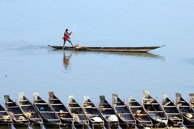 স্বচ্ছ জলের বুকে নৌকা নিয়ে চলছে এক কিশোর। ছবি: আনিস মাহমুদ
