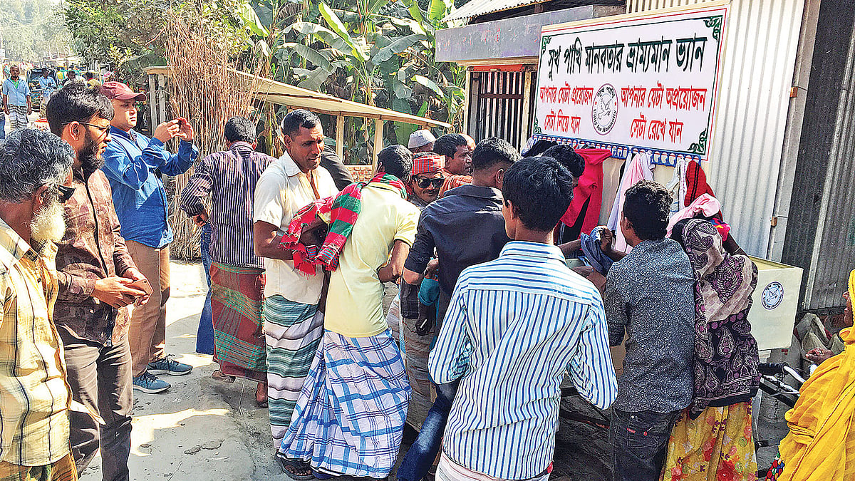 বিনা মূল্যে বিতরণের জন্য ভ্যানে রাখা হয়েছে শীতবস্ত্র। গত শনিবার সিরাজগঞ্জ শহরের চান্দু আলী মোড়ে।  ছবি: প্রথম আলো