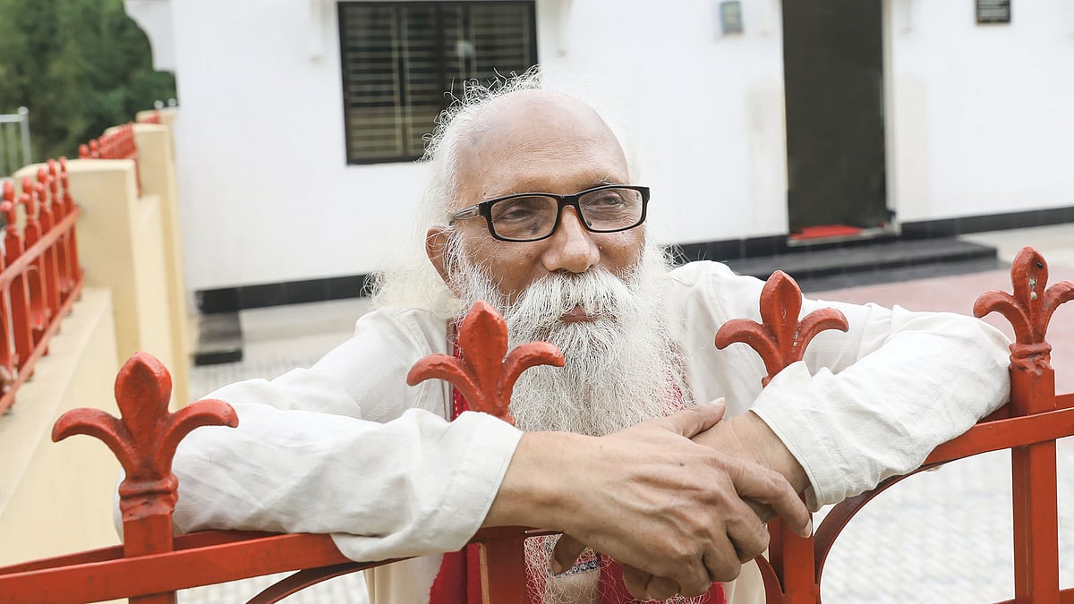 নেত্রকোণার মালিনীতে কবিতাকুঞ্জের প্রাচীরের গ্রিল ধরে নির্মলেন্দু গুণ। ছবি: খালেদ সরকার