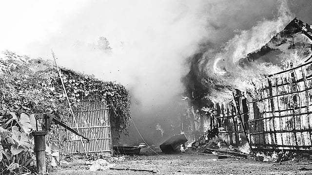 নিহত অটোচালকের বিচারের দাবিতে মানববন্ধন শেষে বাড়ি ফেরার পথে এলাকাবাসী আসামি জসিমের বাড়িতে আগুন ধরিয়ে দেয়। গতকাল বিকেলে নওদাপাড়ার শেখপাড়ায়।  ছবি: প্রথম আলো