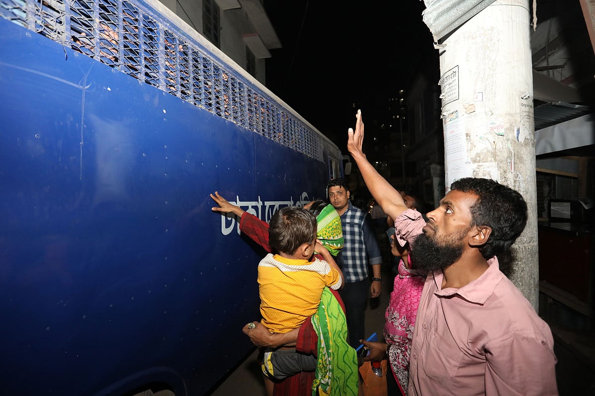 আদালত থেকে কারাগারে নিয়ে যাওয়ার সময় প্রিজনে ভ্যানের পাশে স্বজনেরা। ছবি: দীপু মালাকার