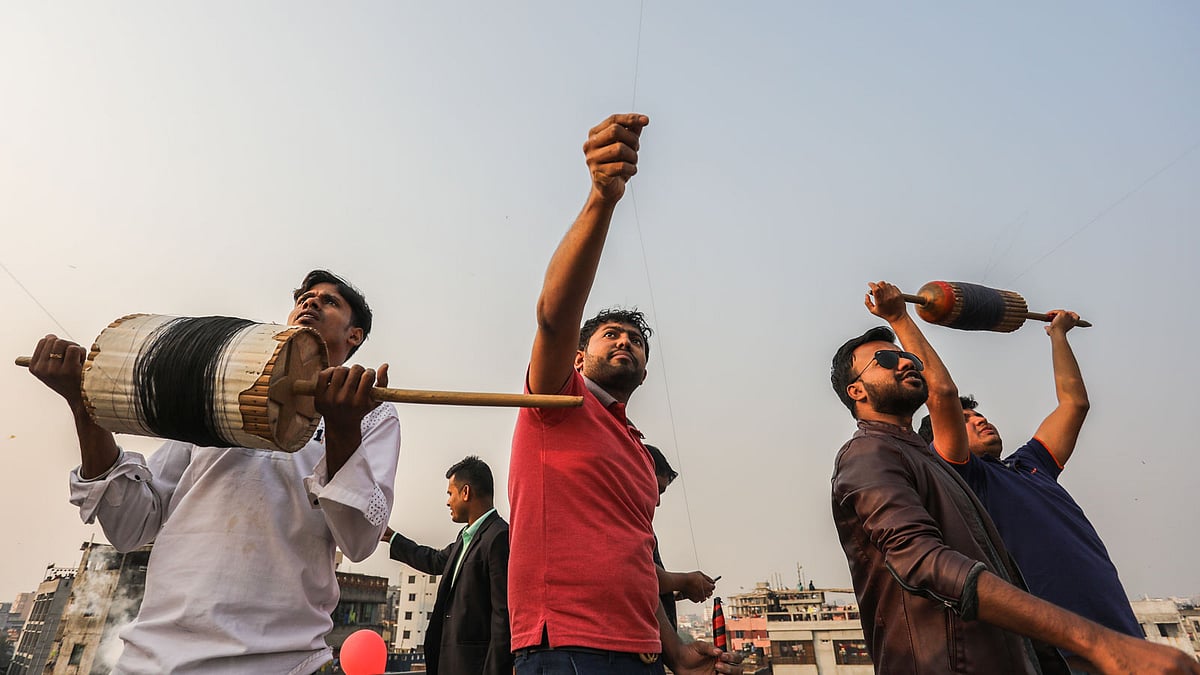 ঘুড়ি ওড়াতে ব্যস্ত কয়েকজন যুবক।