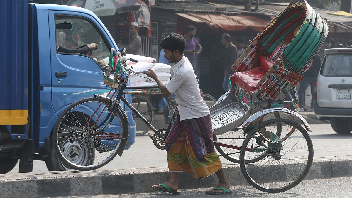 রামপুরা সেতুর সড়ক বিভাজক ডিঙিয়ে রিকশা পার করার চেষ্টা চালাচ্ছেন চালক।