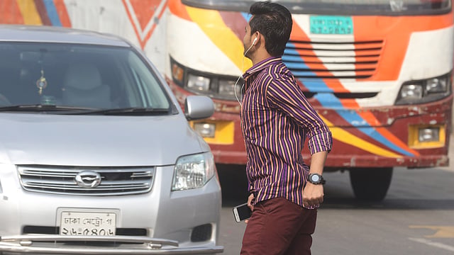 কানে ইয়ারফোন লাগিয়ে দৌড়ে সড়ক পার হচ্ছেন একজন। কাছেই নতুন বাজার মোড়ের পদচারী-সেতু।