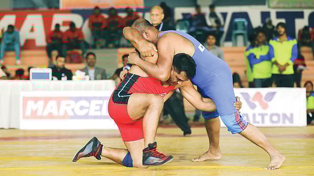 ৩৪তম জাতীয় পুরুষ কুস্তি প্রতিযোগিতার প্রথম পর্বে লড়ছেন কুস্তিগির বিল্লাল হোসেন (লাল জার্সি)। ছবি: তানভীর আহম্মেদ