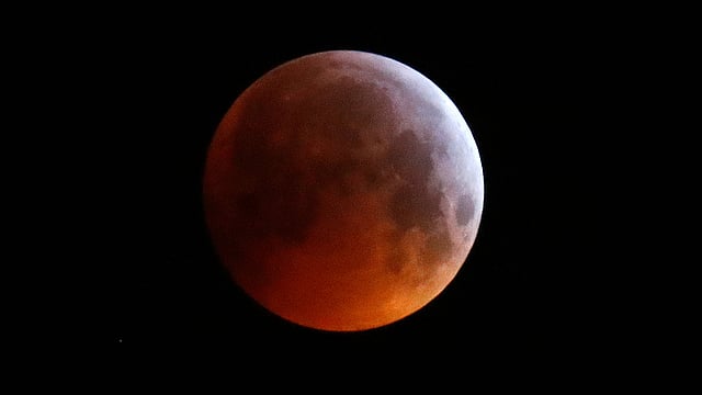 পূর্ণ লাল ‘নেকড়ে চাঁদ’। খুব কম সময়ই চাঁদের এমন রূপ দৃশ্যমান হয়। ছবি: রয়টার্স