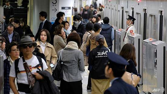 জাপানের টোকিওর রেলস্টেশনে অফিসগামী যাত্রীরা। ছবি: এএফপি