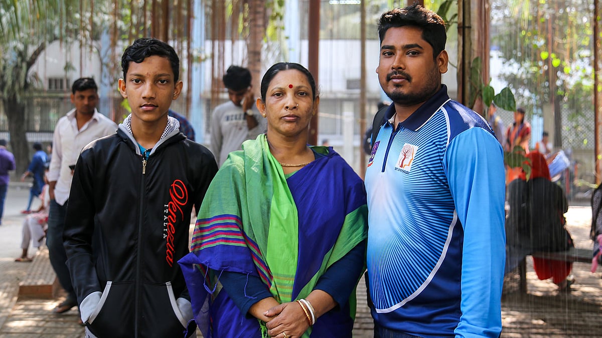 ‘খ’ ইউনিটের ভর্তি পরীক্ষার দিনে হৃদয় সরকারকে মা কোলে করে পরীক্ষার হলে নেওয়া ছবি তোলেন মনোবিজ্ঞান বিভাগের চতুর্থ বর্ষের শিক্ষার্থী এম এ আল মামুন। ফেসবুকে ওই ছবি পোস্টের পরই ব্যাপক সাড়া পড়ে। সেই আল মামুনের সঙ্গে মা ও হৃদয় সরকারের ভাই। ঢাকা বিশ্ববিদ্যালয়, ২২ জানুয়ারি। ছবি: সাবরিনা ইয়াসমীন