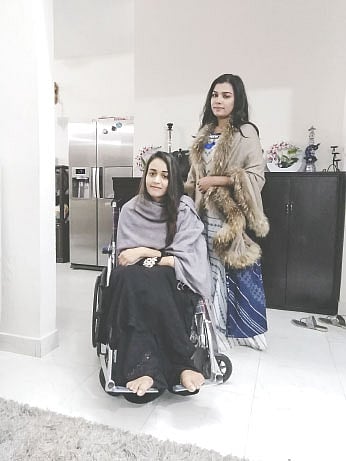 হুইলচেয়ারে বসা আহত অহনা, পেছনে বোন লিজা মিতু