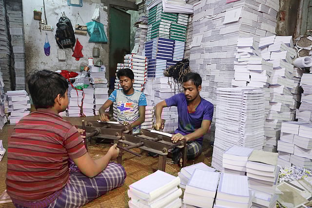 মেশিনের পাশাপাশি হাতেও বাঁধাইয়ের কাজ করা হয়।