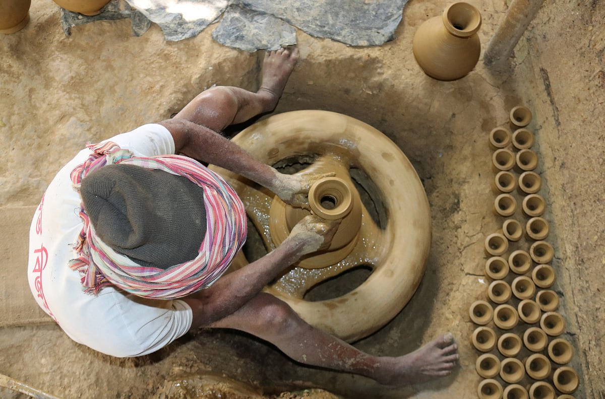 দৈনন্দিন ব্যবহারের জন্য পাহাড়ের অধিবাসীদের কাছে মাটির তৈরি কলস, হাঁড়ি-পাতিল বেশ জনপ্রিয়। মাটির কলস বানানোতে ব্যস্ত এক মৃৎশিল্পী। শালবন কুমারপাড়া, খাগড়াছড়ি, সাম্প্রতিক ছবি। ছবি: নীরব চৌধুরী