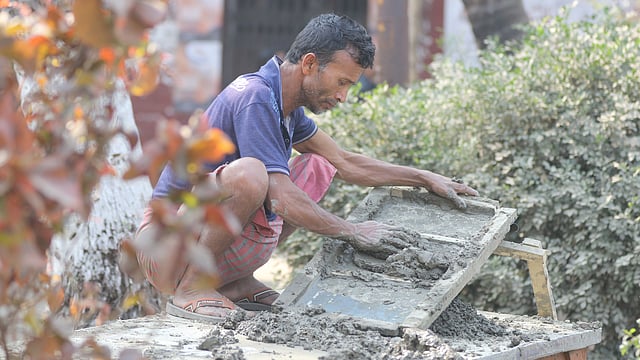 প্রতিমা তৈরির মাটি প্রস্তুত করছেন একজন।