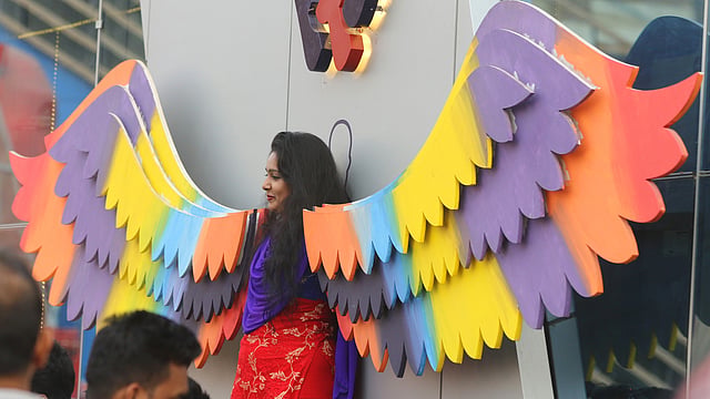 বর্ণিল ডানার সঙ্গে ছবি তুলছেন একজন।