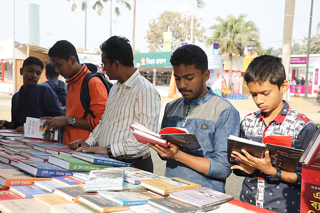 বই কেনার আগে খানিকটা পড়ে নিচ্ছে কয়েকজন।