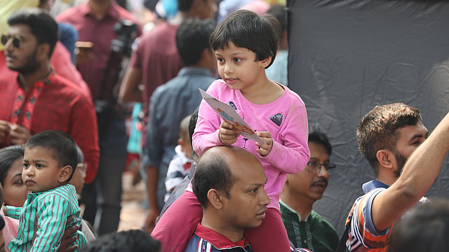 বাবার কাঁধে বসে বইমেলায় এসেছে এই খুদে পাঠক। সোহরাওয়ার্দী উদ্যান, ঢাকা, ৮ ফেব্রুয়ারি। ছবি: আবদুস সালাম