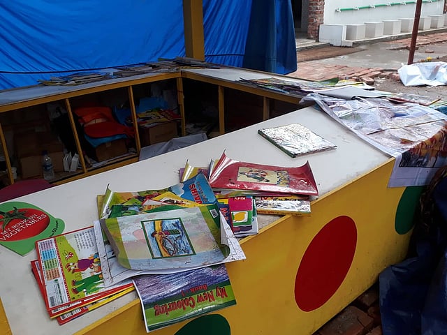 বইমেলার বিভিন্ন স্টলের ভিজে যাওয়া বই শুকানোর চেষ্টা চলছে। বইমেলা, ঢাকা, ১৭ ফেব্রুয়ারি। ছবি: সাজিদ হোসেন